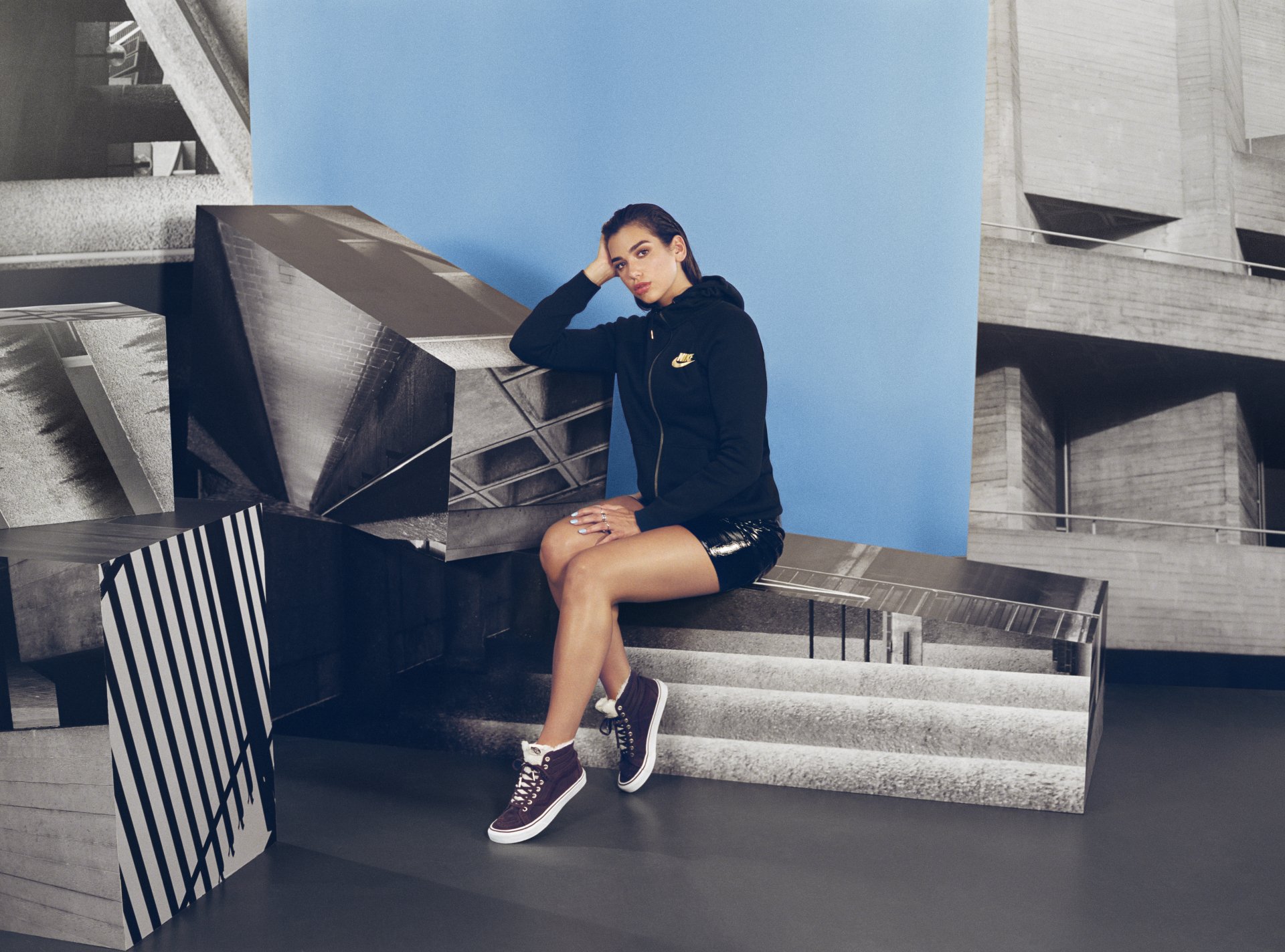 Brunette English singer Dua Lipa poses confidently in a stylish black outfit against an artistic geometric background in this 4K Ultra HD PC desktop wallpaper.