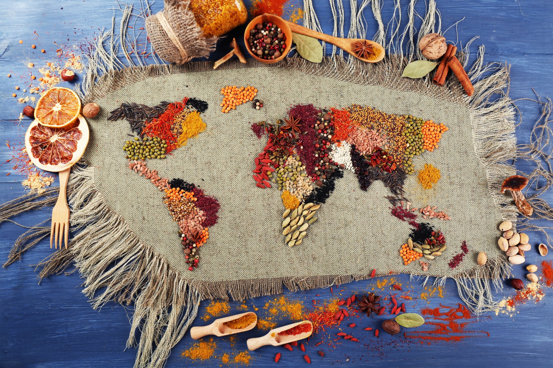 A 4K Ultra HD still life desktop wallpaper featuring a world map creatively formed with colorful herbs and spices on a textured fabric background.
