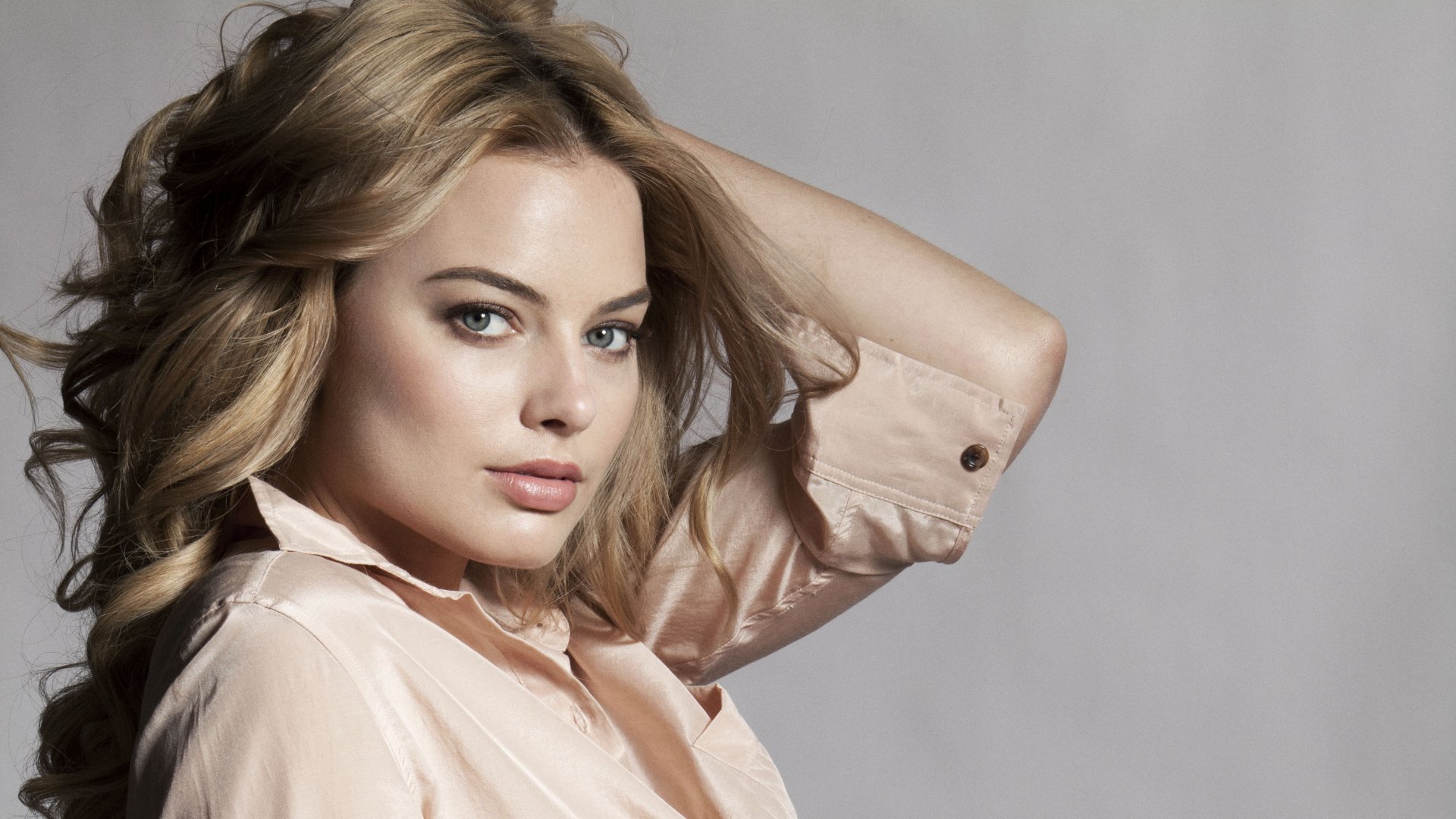 HD PC desktop wallpaper featuring a blonde celebrity, Margot Robbie, posing with a neutral gray background.