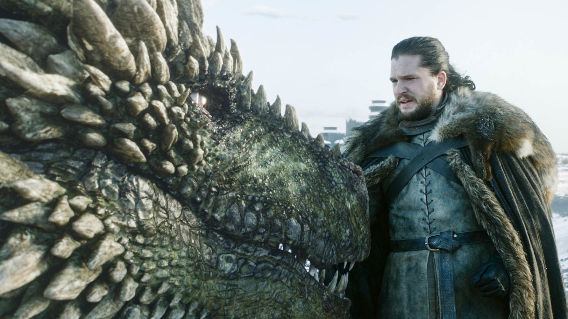 HD desktop wallpaper featuring Kit Harington as Jon Snow from the TV show Game of Thrones, with Jon Snow interacting closely with a dragon.