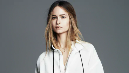 HD wallpaper featuring a poised Katherine Waterston in a white top against a grey backdrop.