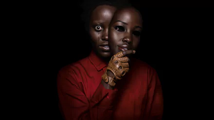 HD desktop wallpaper featuring Lupita Nyong'o from the movie Us, showcasing her eerie dual-faced character in a dark, suspenseful setting.