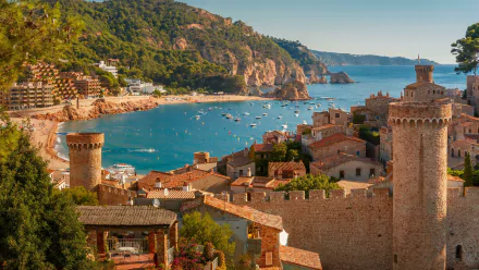 A vibrant 4K Ultra HD view of Tossa de Mar, Spain, showcasing the coastal town's historic towers, Mediterranean coastline, and charming man-made cityscape.