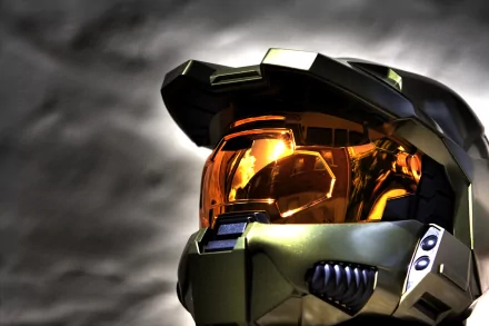 A close-up of an iconic helmet from the video game Halo, featuring a reflective visor and intricate detailing, serves as a striking HD desktop wallpaper and background.