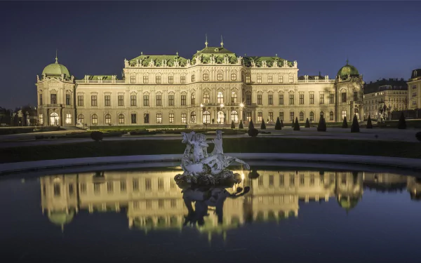 HD desktop wallpaper featuring a beautifully illuminated man-made palace at night, reflected in a calm water fountain in the foreground.