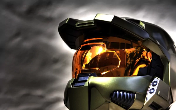 A close-up of an iconic helmet from the video game Halo, featuring a reflective visor and intricate detailing, serves as a striking HD desktop wallpaper and background.