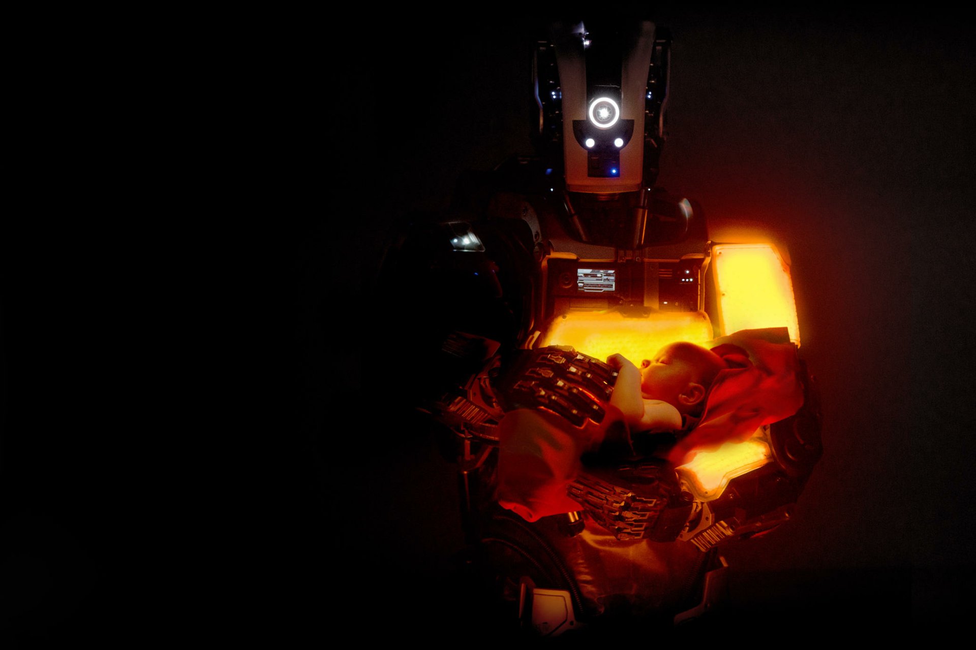 HD wallpaper featuring a scene from I Am Mother with a robot against a dark background illuminated by an orange light.