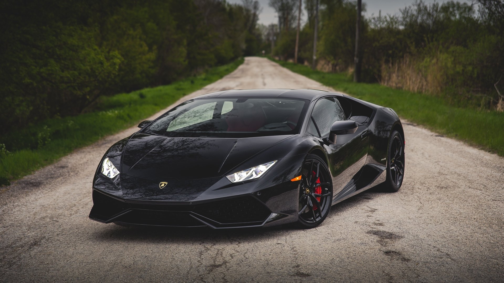 A sleek black Lamborghini Huracan LP 610-4 supercar parked on a rural road, captured in stunning 4K Ultra HD as a PC desktop wallpaper and background.
