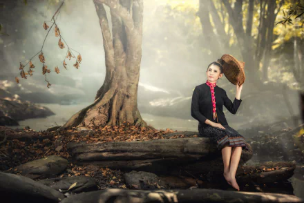 Asian woman model with black hair in traditional dress and conical hat, seated on forest roots in misty woods — 5K Ultra HD PC desktop wallpaper.
