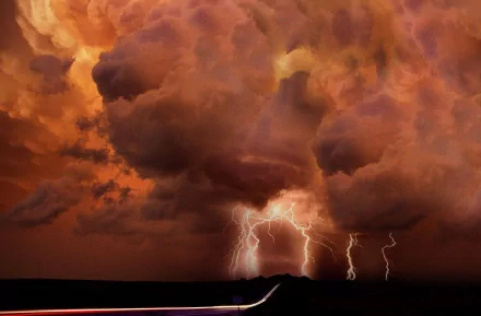 HD PC desktop wallpaper featuring dramatic lightning striking beneath dark, fiery orange storm clouds captured in stunning photography.