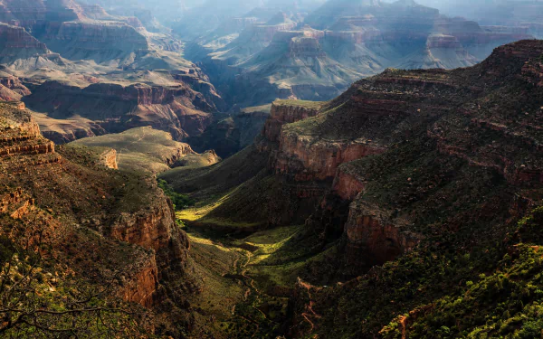 HD desktop wallpaper showcasing a breathtaking view of a canyon in the USA, surrounded by majestic mountains and lush green valleys, capturing the beauty of nature.