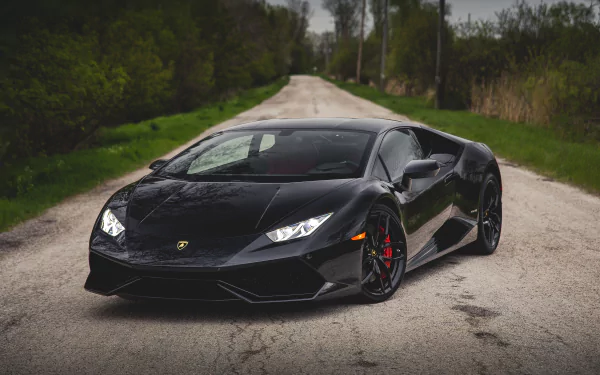 A sleek black Lamborghini Huracan LP 610-4 supercar parked on a rural road, captured in stunning 4K Ultra HD as a PC desktop wallpaper and background.