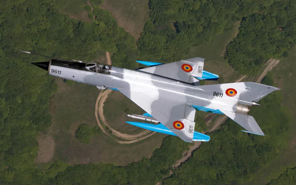 HD desktop wallpaper of a Mikoyan-Gurevich MiG-21 jet fighter warplane soaring over a green landscape, showcasing its sleek military aircraft design.