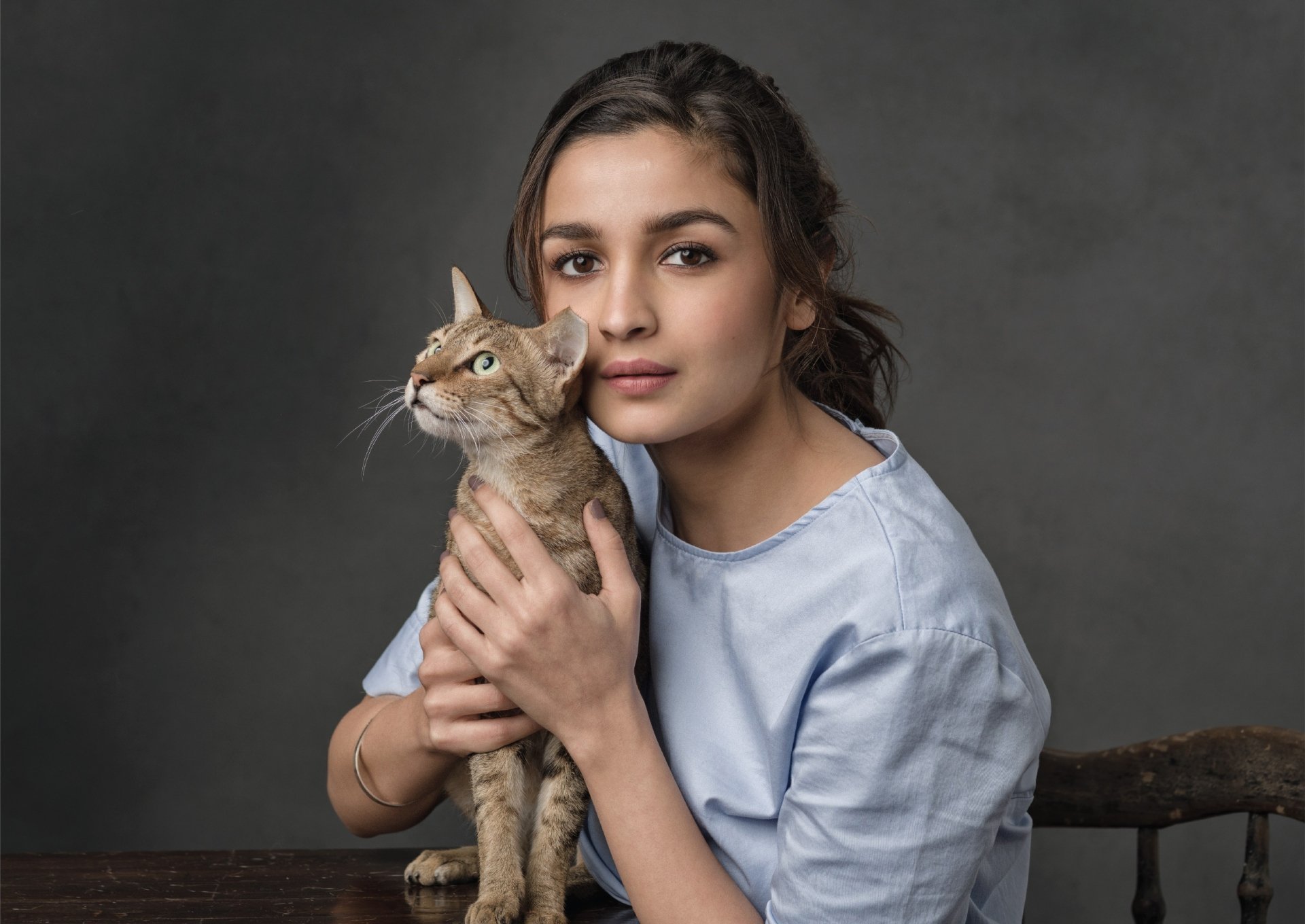 HD desktop wallpaper featuring actress Alia Bhatt, a brunette, holding a cat against a neutral background.