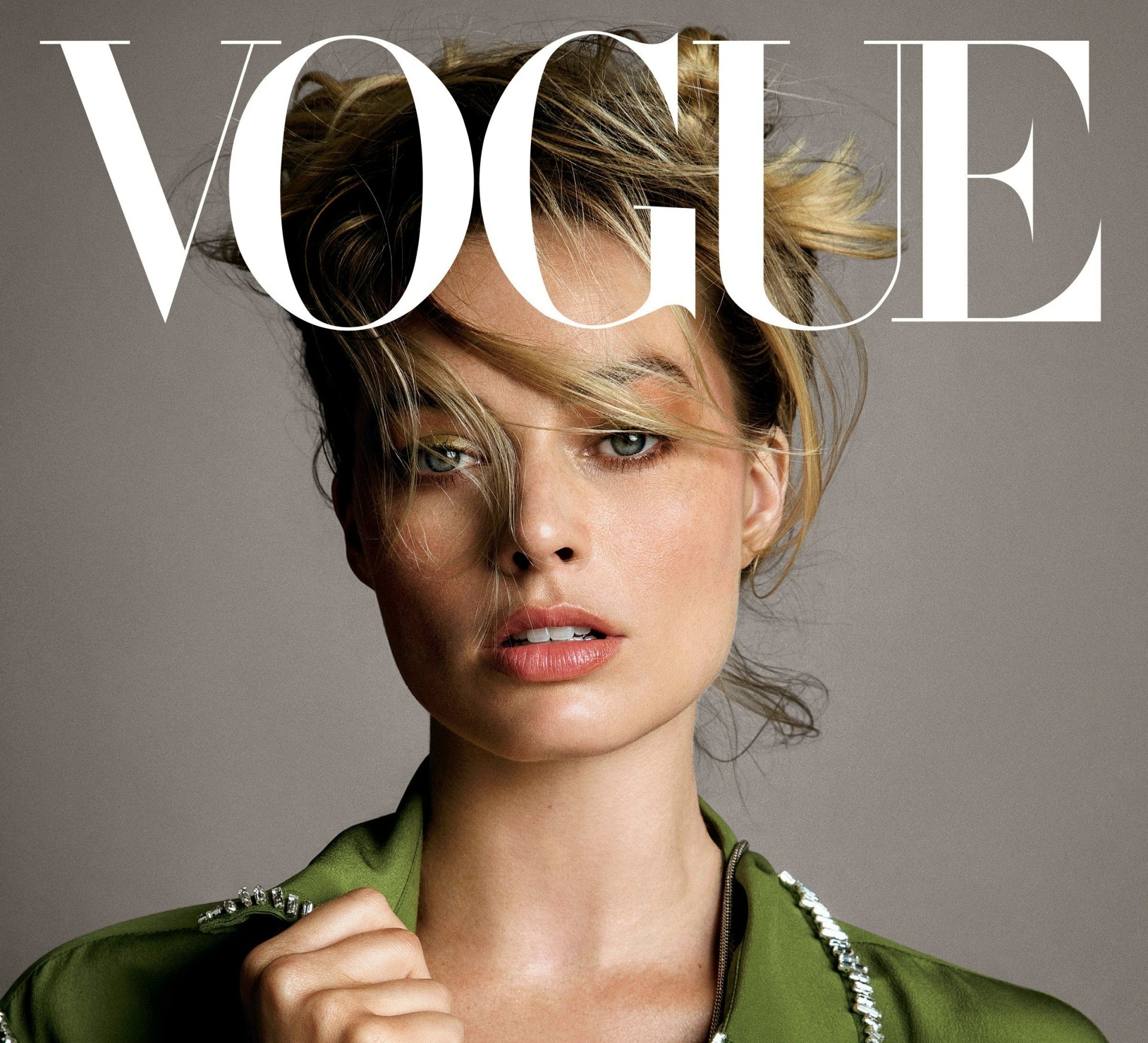 Close-up of Australian actress Margot Robbie with blonde hair and blue eyes on the cover of Vogue, featured as an HD PC desktop wallpaper and background.