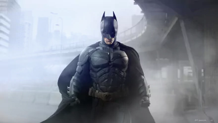 HD desktop wallpaper of Batman from DC Comics' movie The Dark Knight Rises, featuring the iconic superhero standing in a foggy urban setting with a determined expression.
