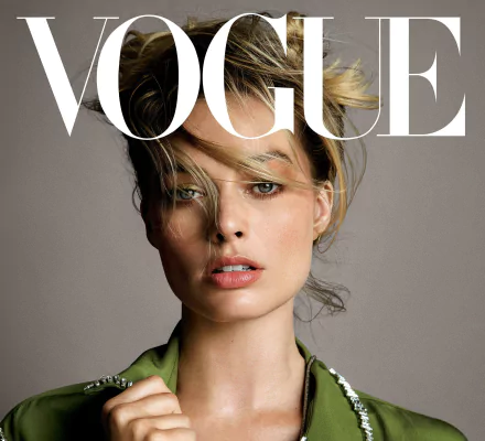 Close-up of Australian actress Margot Robbie with blonde hair and blue eyes on the cover of Vogue, featured as an HD PC desktop wallpaper and background.