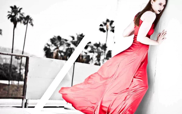 A striking HD wallpaper from the TV show True Blood features a woman in a flowing red dress against a monochrome background with palm trees, exuding mystery and allure.