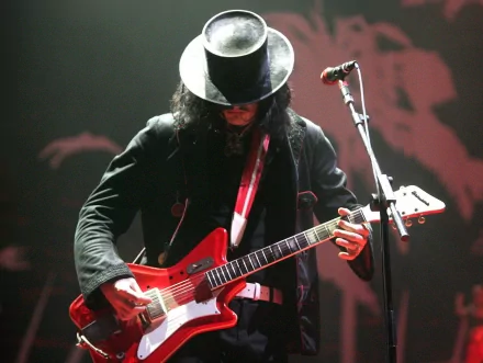 HD desktop wallpaper featuring a musician from The White Stripes playing an electric guitar on stage under dramatic lighting.