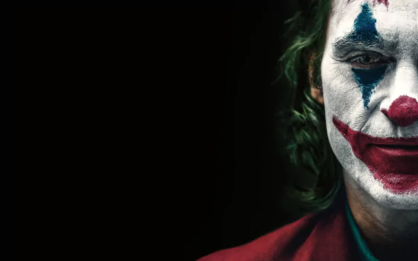 HD desktop wallpaper featuring Joaquin Phoenix as Arthur Fleck from the DC Comics movie Joker, showing a close-up of his face painted in the iconic Joker makeup against a dark background.