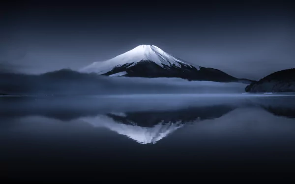 HD PC desktop wallpaper background: tranquil nature scene of snow-capped Mount Fuji at night reflected in a glassy lake under a deep blue sky.