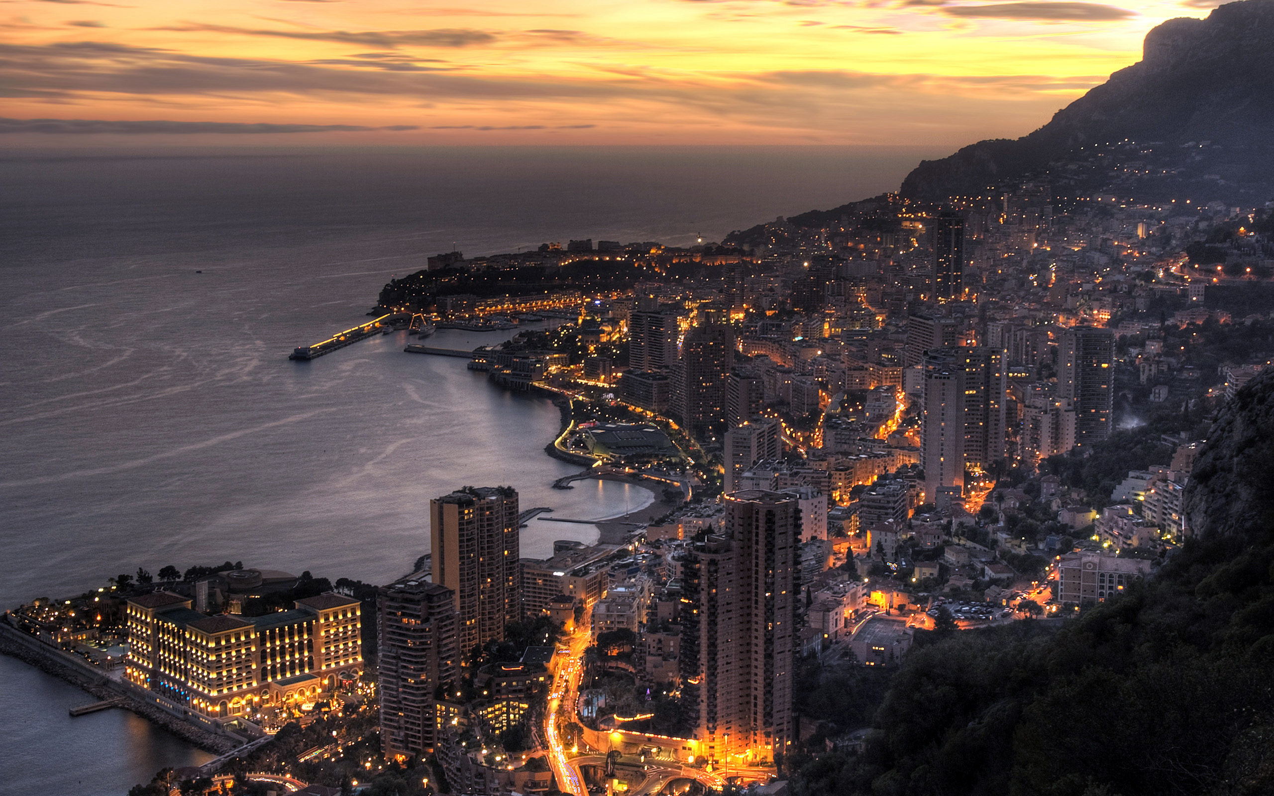 Coastline view of Monte Carlo city at dusk, overlooking the Mediterranean Sea in Monaco.