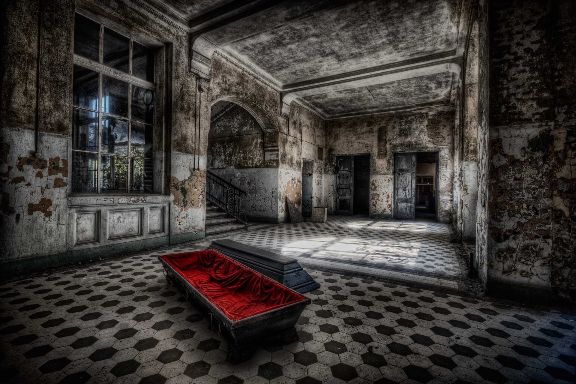 A hauntingly dark and artistic HD wallpaper featuring a dilapidated room with ornate architecture, a striking red coffin, and dramatic light contrasting with the aged surroundings.