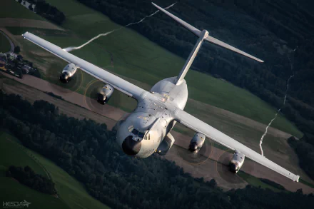 Airbus A400M military transport aircraft in flight over patchwork fields, HD PC desktop wallpaper background.