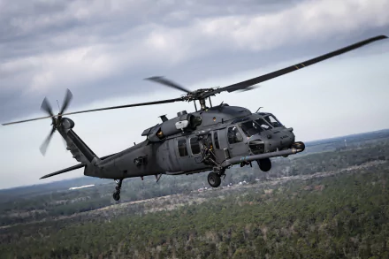 A Sikorsky HH-60 Pave Hawk military helicopter in flight over a forested landscape, captured in sharp detail for a 4K Ultra HD PC desktop wallpaper.