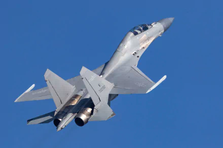 Shenyang J-16 military jet fighter warplane banking in flight against a clear blue sky — HD PC desktop wallpaper/background