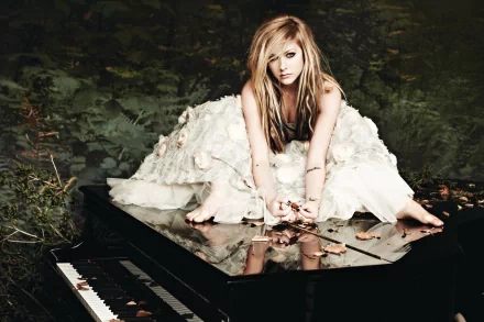 A blonde Canadian singer, Avril Lavigne, poses elegantly on a grand piano, surrounded by nature, showcasing her artistic style in this HD desktop wallpaper.