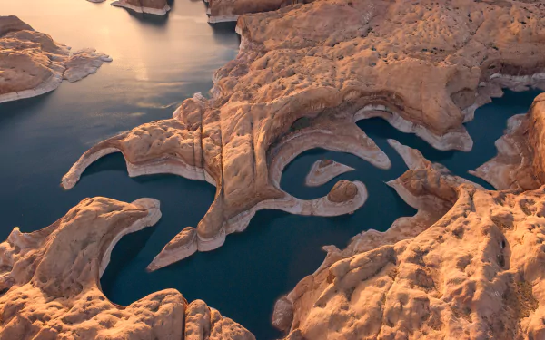 Aerial view of Lake Powell’s winding blue waters surrounded by rugged orange rock formations, captured in an HD nature desktop wallpaper.