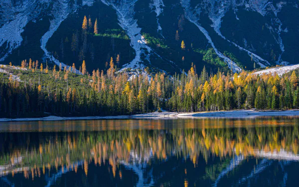4K Ultra HD desktop wallpaper of Italy's serene mountain lake with vibrant autumn trees reflecting perfectly on the calm water, showcasing stunning natural beauty.