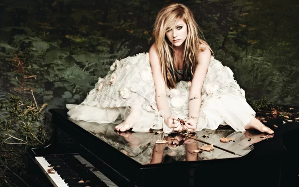 A blonde Canadian singer, Avril Lavigne, poses elegantly on a grand piano, surrounded by nature, showcasing her artistic style in this HD desktop wallpaper.