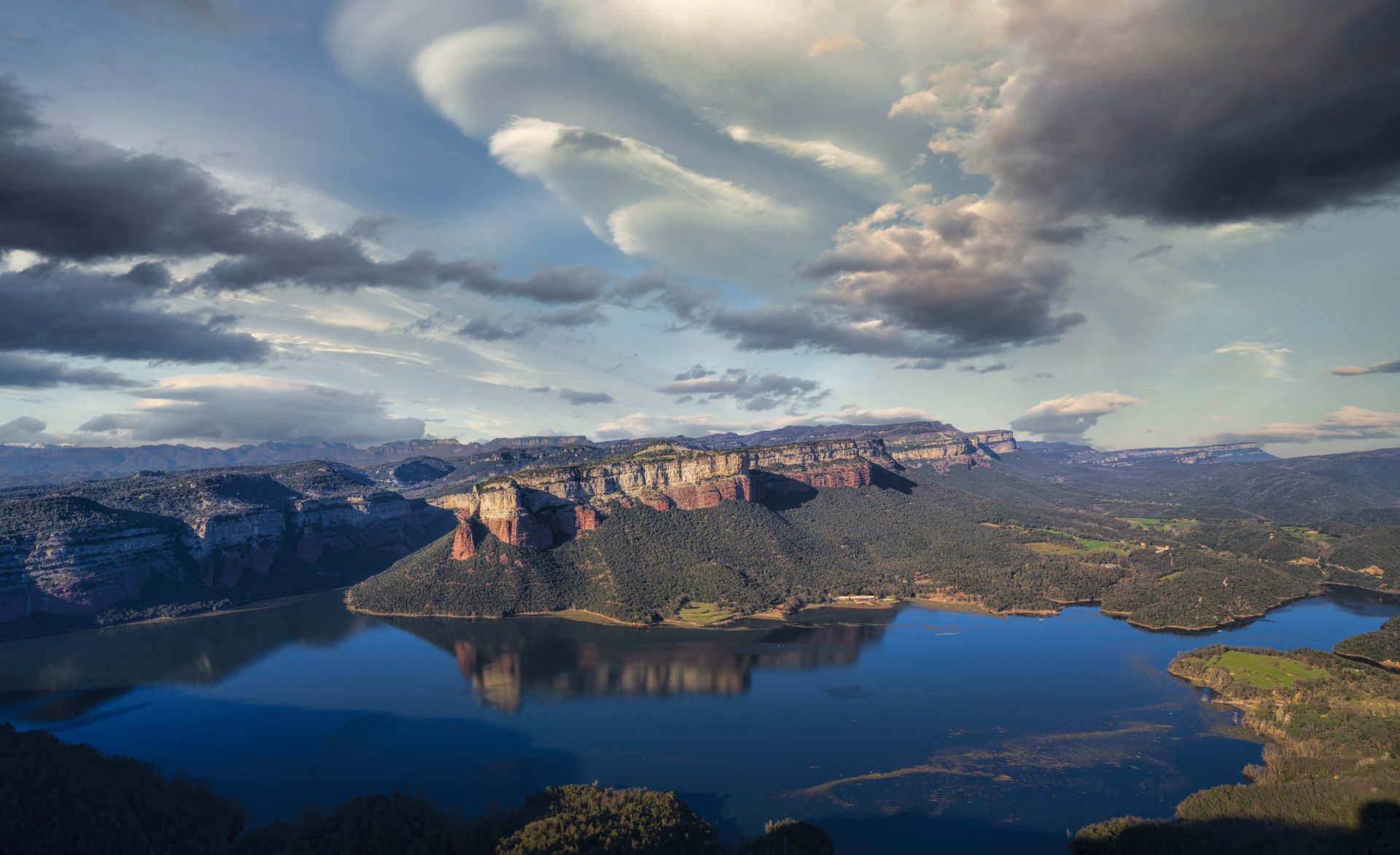 4K Ultra HD PC desktop wallpaper showcasing a serene mountain landscape with a canyon, calm lake, and dramatic cloud-filled sky.