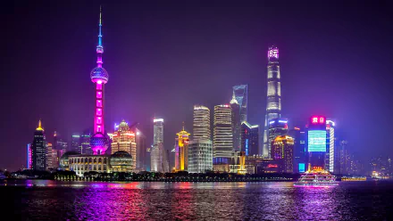 5K Ultra HD night cityscape of Shanghai with the illuminated Oriental Pearl Tower and skyscrapers reflecting on the river — vibrant man-made desktop wallpaper.