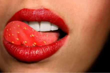 Close-up of a woman’s lips with red lipstick, tongue touching the upper teeth, featured as a vibrant HD PC desktop wallpaper and background.