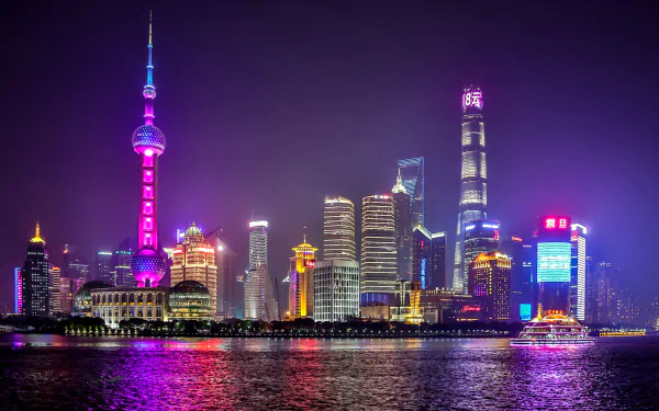 5K Ultra HD night cityscape of Shanghai with the illuminated Oriental Pearl Tower and skyscrapers reflecting on the river — vibrant man-made desktop wallpaper.