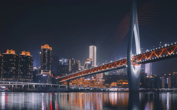 Chongqing night skyline with illuminated skyscrapers and a lit cable-stayed bridge reflected on the river, 4K Ultra HD PC desktop wallpaper of a man-made cityscape in China.