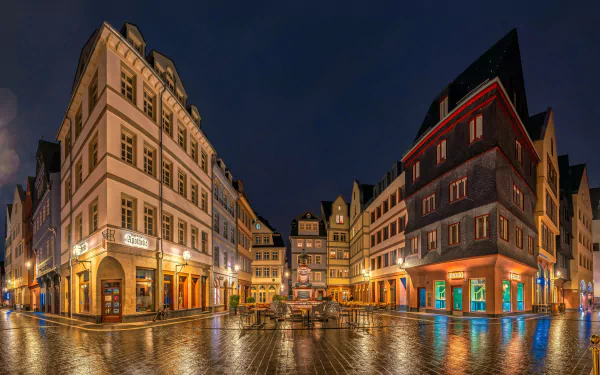 Nighttime cityscape of illuminated historic buildings in Frankfurt, Germany, showcasing vibrant lights and reflections in a 4K Ultra HD desktop wallpaper.