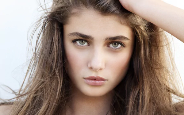 Close-up 4K Ultra HD desktop wallpaper of an American brunette model woman with blue eyes and an intense gaze, face centered with hair framing her features.