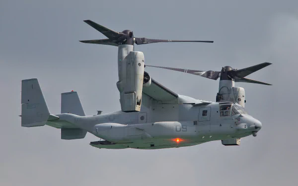 HD desktop wallpaper of a Bell Boeing V-22 Osprey, a military transport aircraft, captured in flight against a clear sky background.