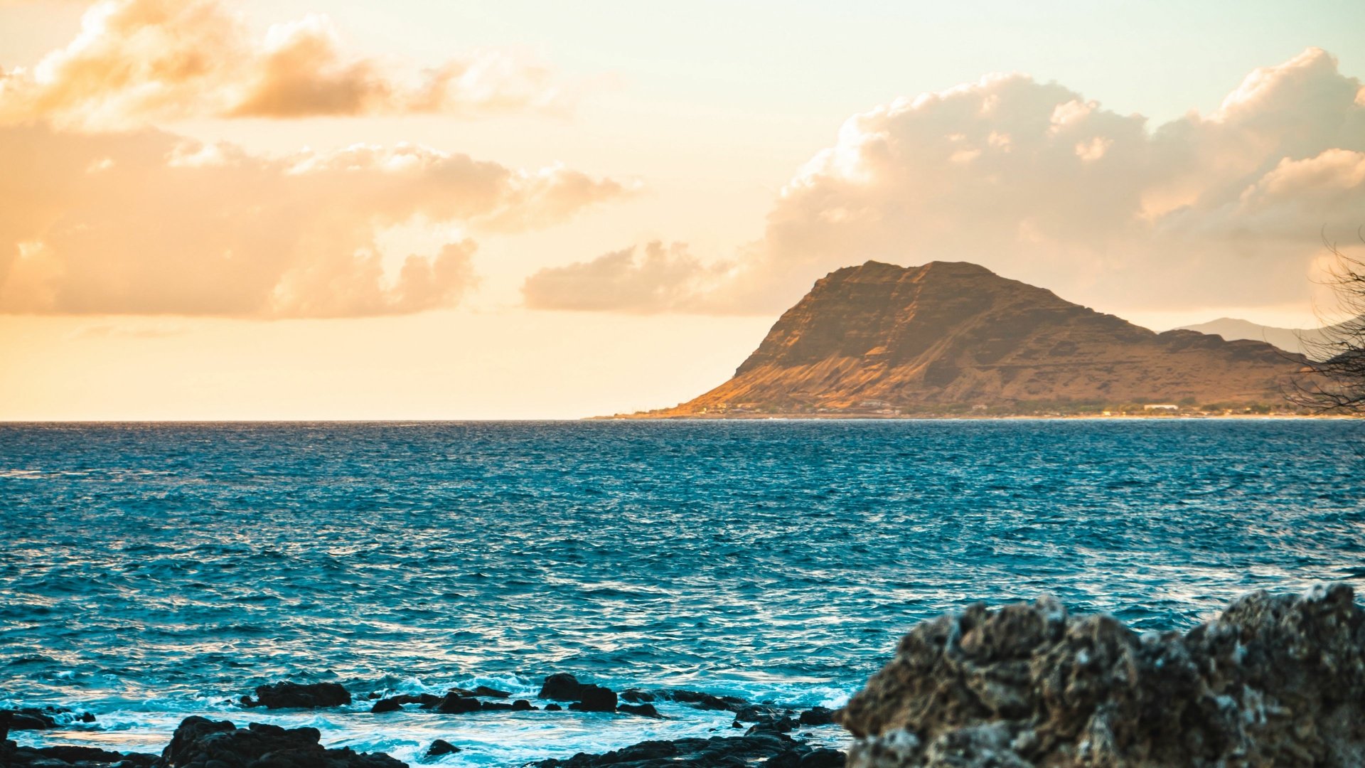 4K Ultra HD PC desktop wallpaper and background: nature, ocean scene with rocky foreground, turquoise waves and a sunlit island headland beneath golden clouds.