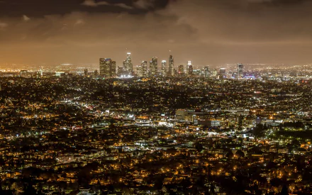 Aerial view of Los Angeles cityscape at night with illuminated buildings and streets, captured in 4K Ultra HD as a man-made urban landscape.