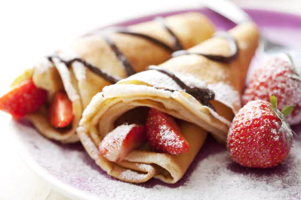 HD desktop wallpaper featuring breakfast crêpes filled with fresh strawberries and drizzled with chocolate, accompanied by whole strawberries on a white plate.