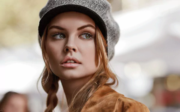 HD desktop wallpaper: close-up portrait of a Russian woman model in a gray beret, braided hair and brown coat against a soft, out-of-focus urban background.