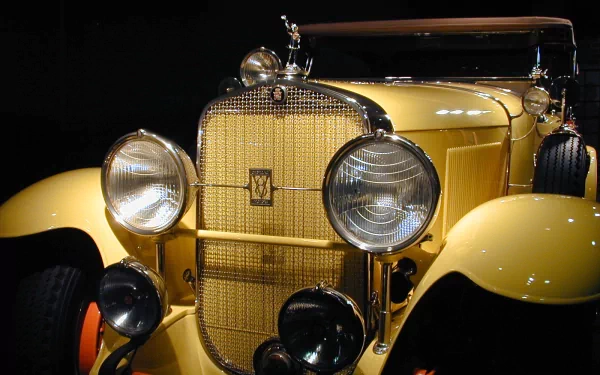 Close-up of a yellow 1929 Cadillac V-8 Dual Cowl Phaeton with detailed headlights and grille, featured as an HD PC desktop wallpaper and background.