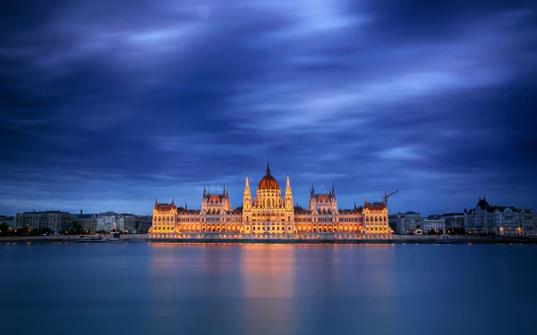 Illuminated Hungarian Parliament Building, a man-made landmark on the Danube in Budapest, reflected at dusk — 5K Ultra HD PC desktop wallpaper.