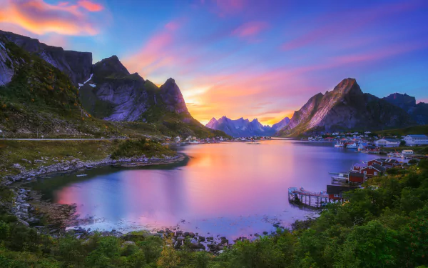 HD desktop wallpaper of Reine, Norway, capturing a serene lake with clear reflections of island mountains during sunset. This stunning Lofoten photography depicts vibrant, colorful skies.