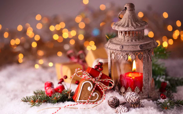 Holiday-themed HD PC desktop wallpaper featuring a rustic lantern with a lit candle, festive decorations, pinecones, and warm Christmas bokeh lights in the background.